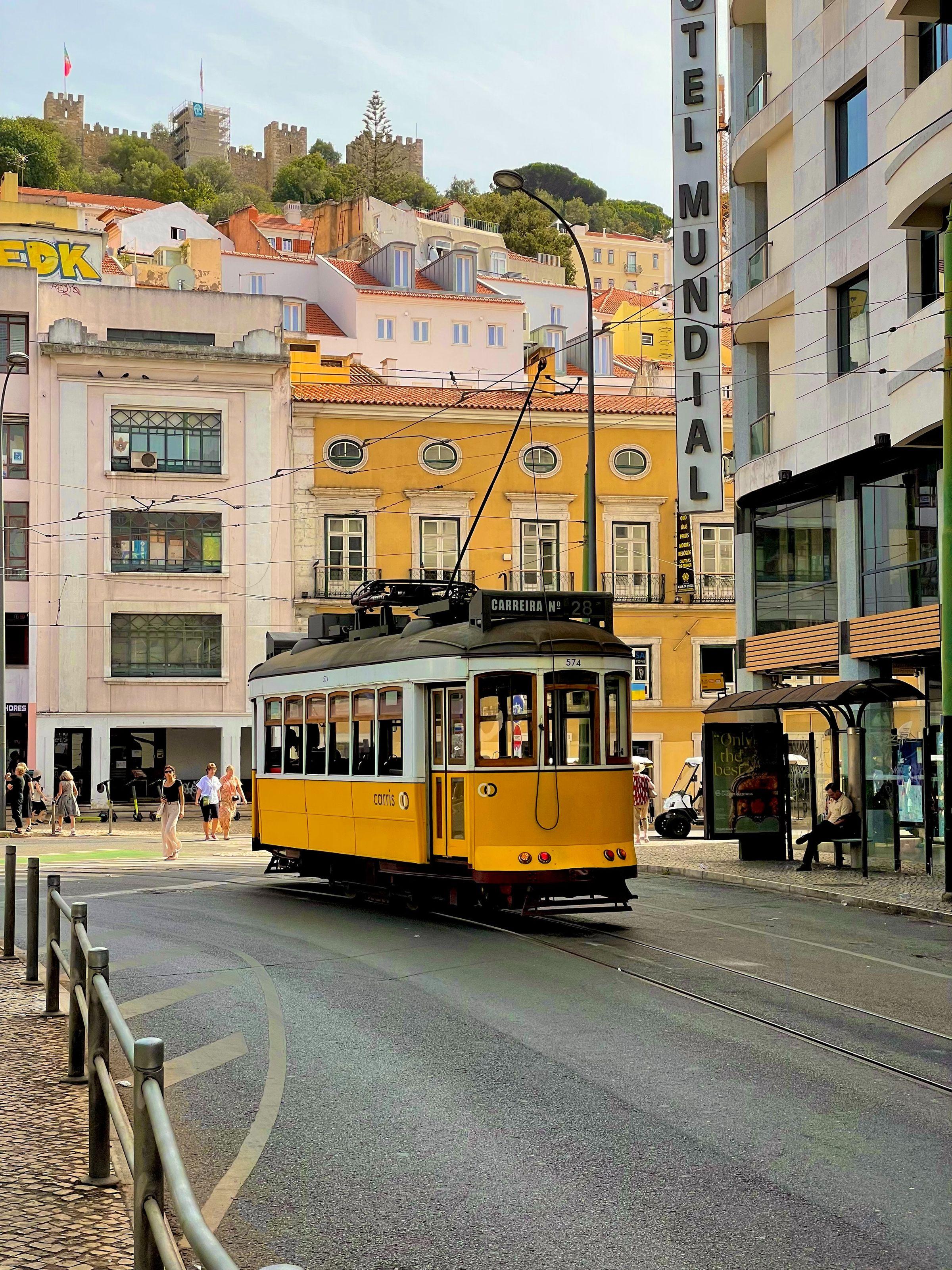 representative image of Lisbon. Yellow tram on the tracks on a street in Lisbon, on a sunny day